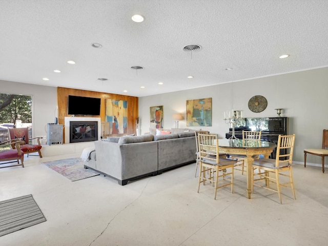 living room with a tiled fireplace and a textured ceiling