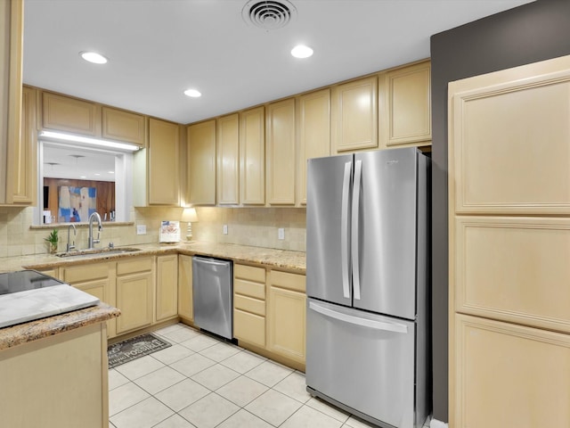 kitchen with light brown cabinetry, sink, light tile patterned floors, stainless steel appliances, and backsplash