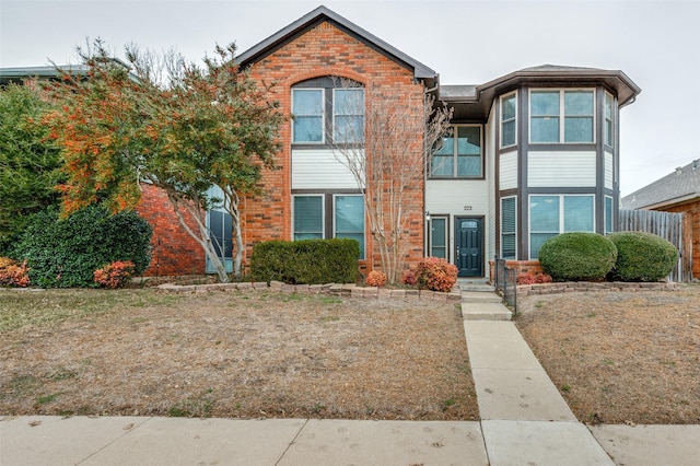 townhome / multi-family property featuring brick siding and fence