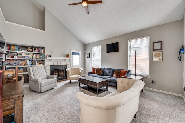living area with a ceiling fan, a fireplace, carpet flooring, baseboards, and high vaulted ceiling