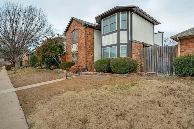 view of home's exterior with brick siding and fence