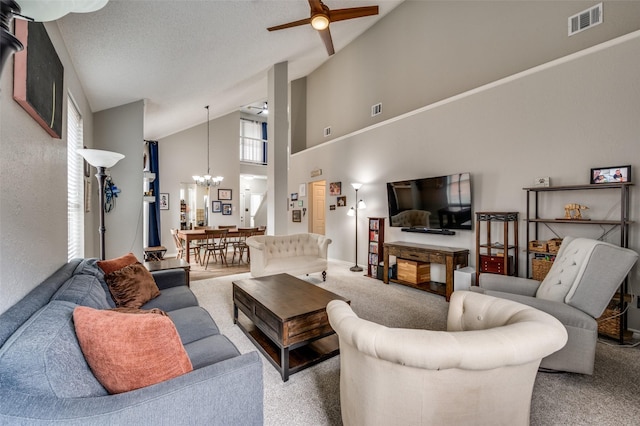 living area with a chandelier, carpet, a ceiling fan, and high vaulted ceiling