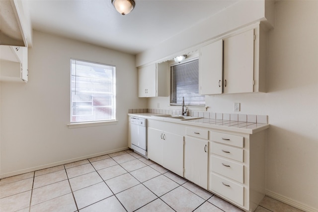 kitchen featuring white dishwasher, sink, tile countertops, and white cabinets