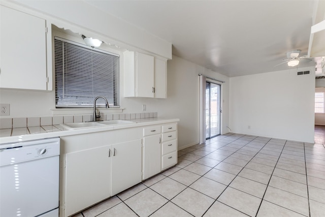 kitchen with sink, light tile patterned floors, ceiling fan, white dishwasher, and white cabinets