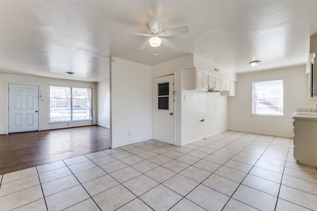 unfurnished living room with light tile patterned flooring and ceiling fan