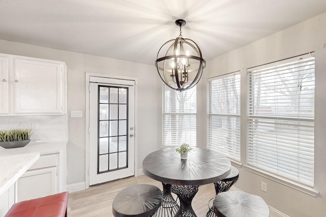 dining room with a notable chandelier and light wood-type flooring