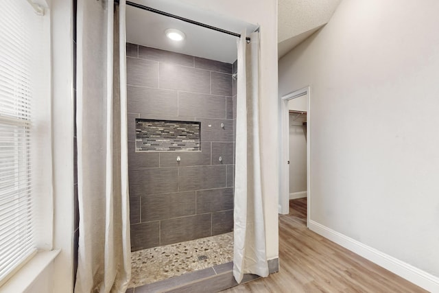 bathroom featuring wood-type flooring and tiled shower