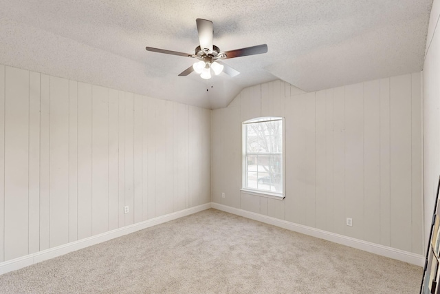 unfurnished room with ceiling fan, light colored carpet, and a textured ceiling