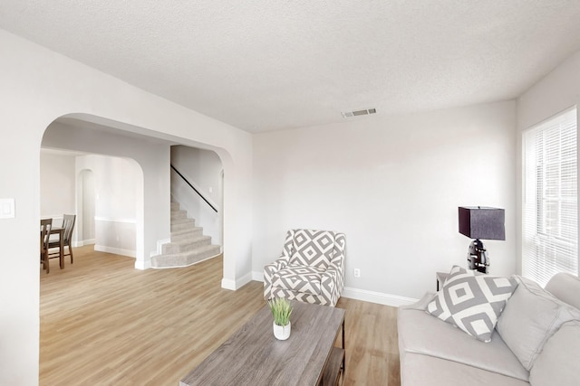 living room with hardwood / wood-style flooring and a textured ceiling