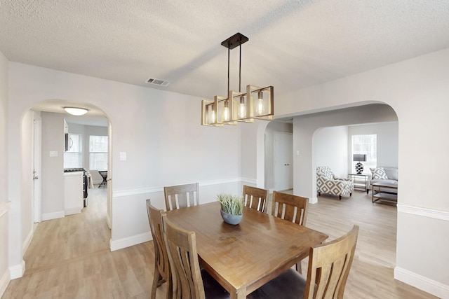 dining area featuring light hardwood / wood-style flooring and a textured ceiling