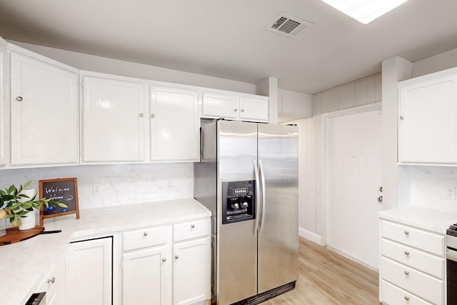 kitchen featuring white cabinetry, stainless steel fridge, and light hardwood / wood-style flooring