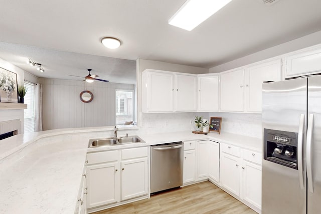 kitchen featuring appliances with stainless steel finishes, sink, white cabinets, and light hardwood / wood-style floors