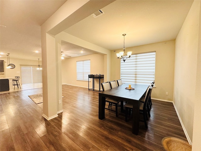 dining room with dark hardwood / wood-style floors and ceiling fan with notable chandelier