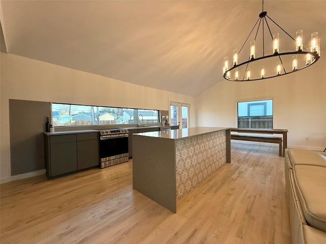 kitchen with a healthy amount of sunlight, sink, light hardwood / wood-style flooring, and decorative light fixtures