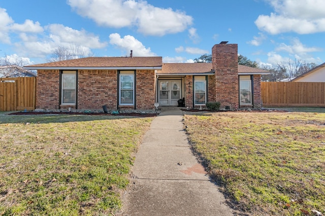 ranch-style home featuring french doors and a front lawn