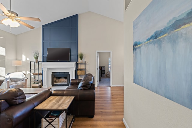 living room featuring hardwood / wood-style flooring, lofted ceiling, a fireplace, and ceiling fan