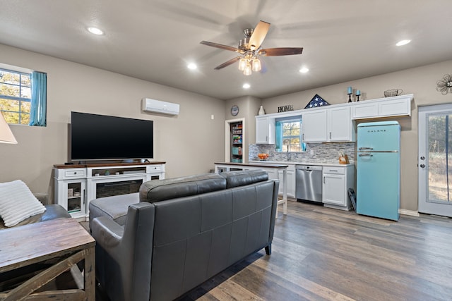 living room featuring sink, dark hardwood / wood-style floors, an AC wall unit, and ceiling fan