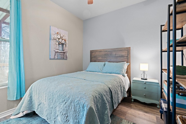 bedroom with multiple windows, dark wood-type flooring, and ceiling fan