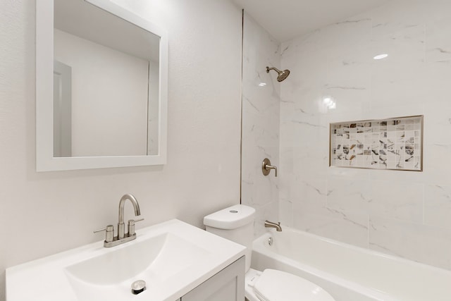 full bathroom featuring vanity, tiled shower / bath combo, and toilet