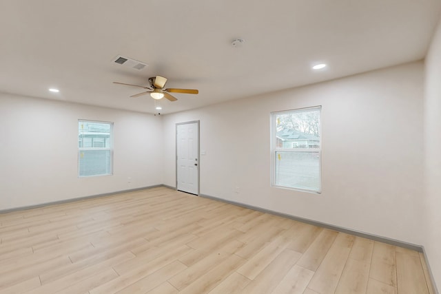 empty room with ceiling fan, light hardwood / wood-style flooring, and a wealth of natural light