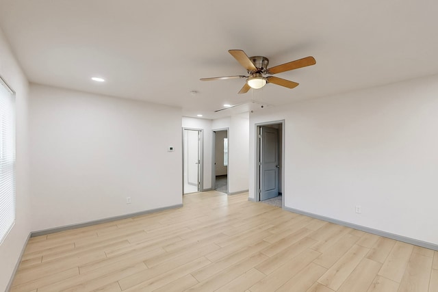 spare room featuring recessed lighting, baseboards, light wood-style floors, and a ceiling fan