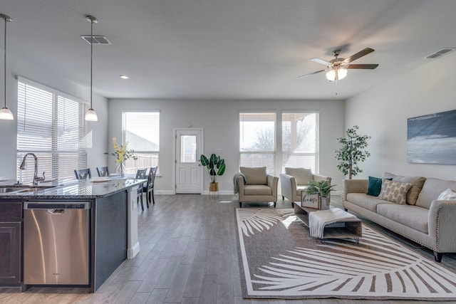 living room featuring ceiling fan, dark hardwood / wood-style floors, and sink