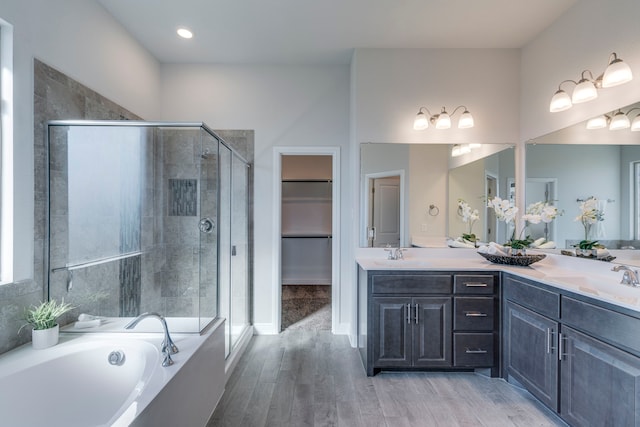 bathroom with hardwood / wood-style flooring, vanity, and shower with separate bathtub