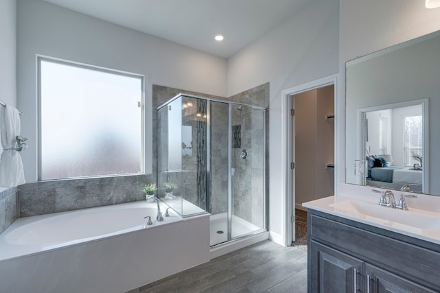 bathroom featuring hardwood / wood-style flooring, plus walk in shower, and vanity