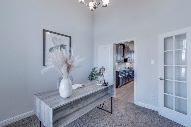 carpeted office featuring a notable chandelier