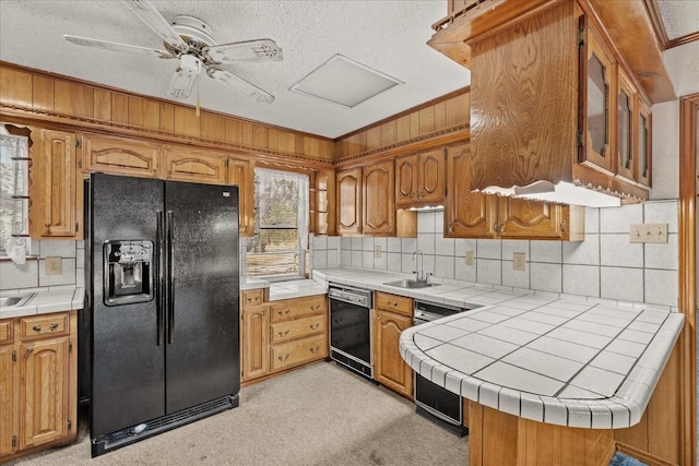 kitchen featuring sink, tile countertops, kitchen peninsula, ceiling fan, and black appliances