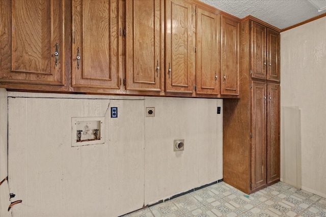 laundry area featuring cabinets, washer hookup, hookup for an electric dryer, and a textured ceiling