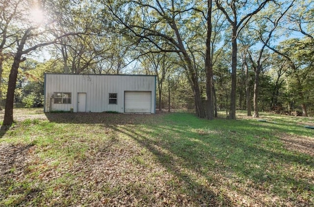 view of outdoor structure with a yard and a garage