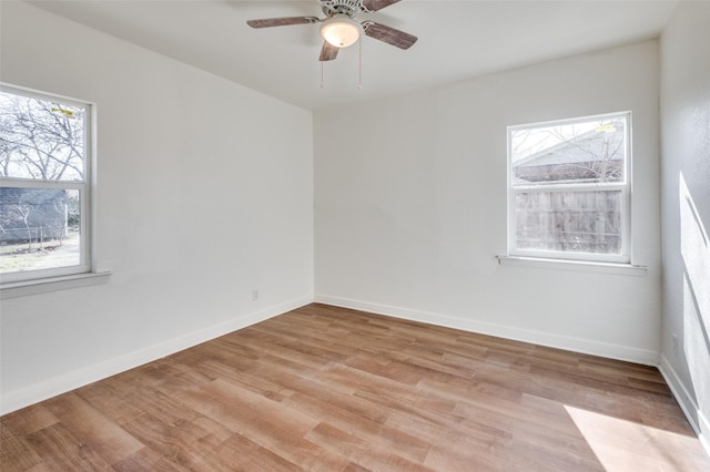 empty room featuring ceiling fan, plenty of natural light, and light hardwood / wood-style floors