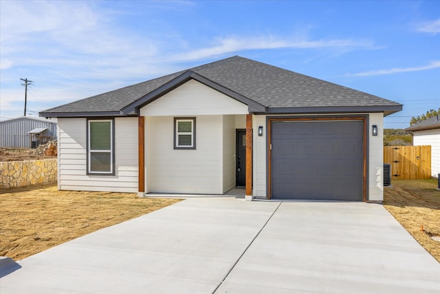 view of front of house with a garage and central AC