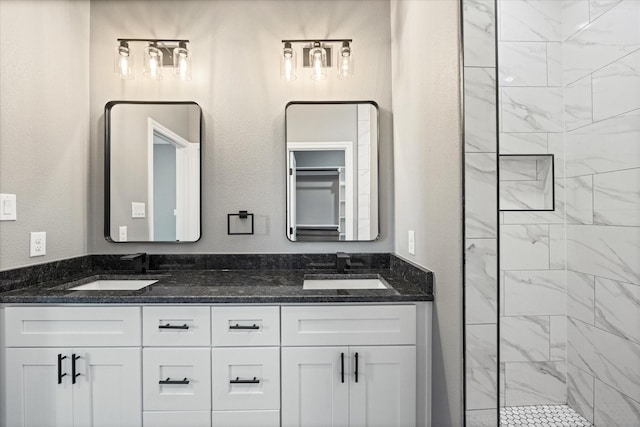 bathroom with vanity and a tile shower