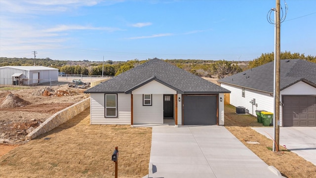 view of front of home with a garage and central AC