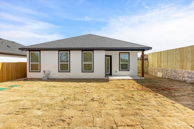 rear view of house featuring a yard and a patio area