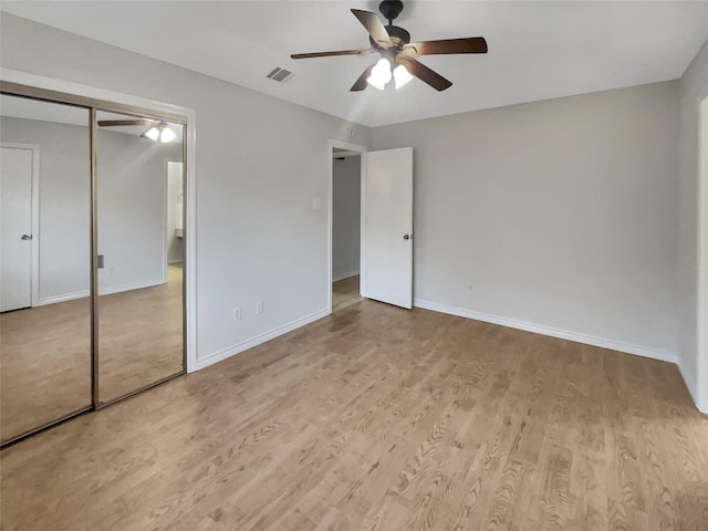 unfurnished bedroom with light hardwood / wood-style flooring, a closet, and ceiling fan