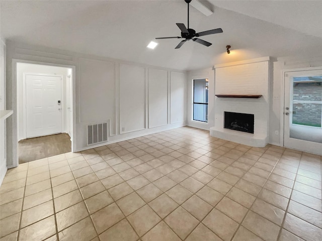 unfurnished living room featuring light tile patterned flooring, ceiling fan, a fireplace, and lofted ceiling with beams