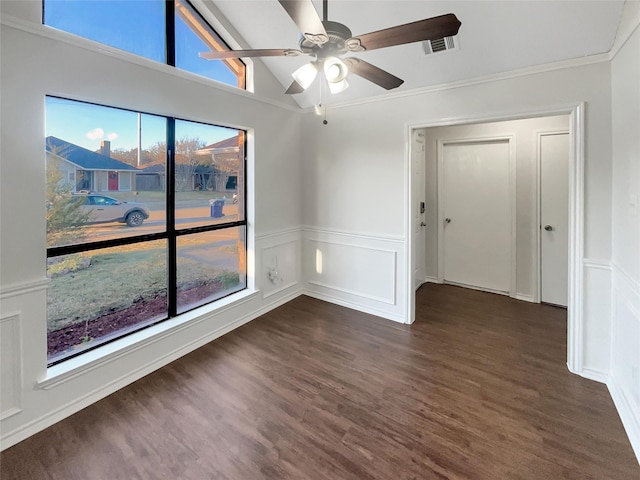 unfurnished room with vaulted ceiling, plenty of natural light, dark hardwood / wood-style floors, and crown molding