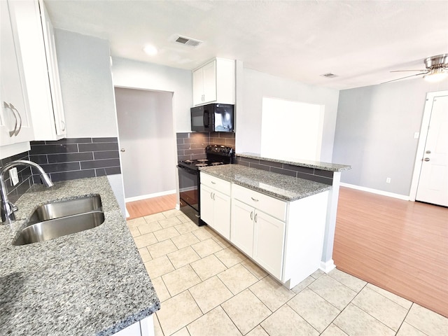 kitchen featuring sink, black appliances, dark stone countertops, white cabinets, and backsplash