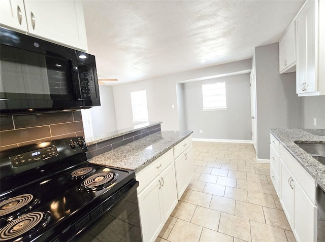 kitchen featuring white cabinetry, light stone countertops, tasteful backsplash, and black appliances