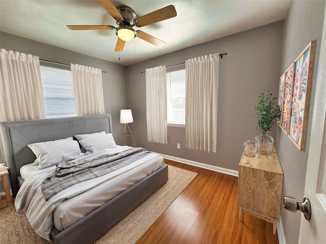 bedroom with ceiling fan and light hardwood / wood-style floors