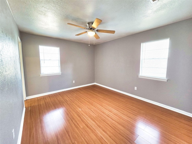 empty room featuring hardwood / wood-style floors, a textured ceiling, and ceiling fan