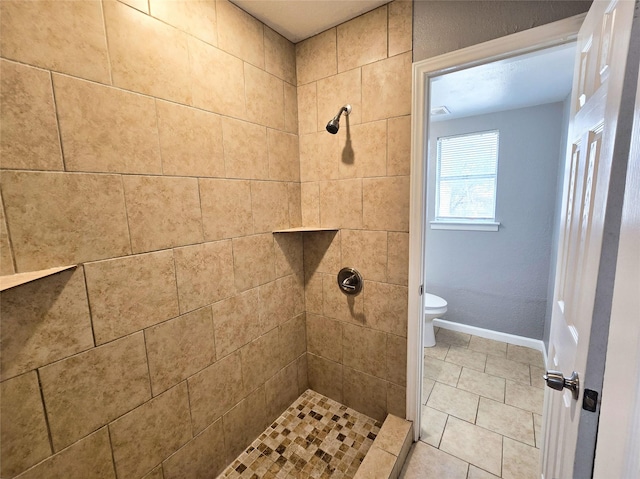 bathroom with tiled shower, tile patterned floors, and toilet