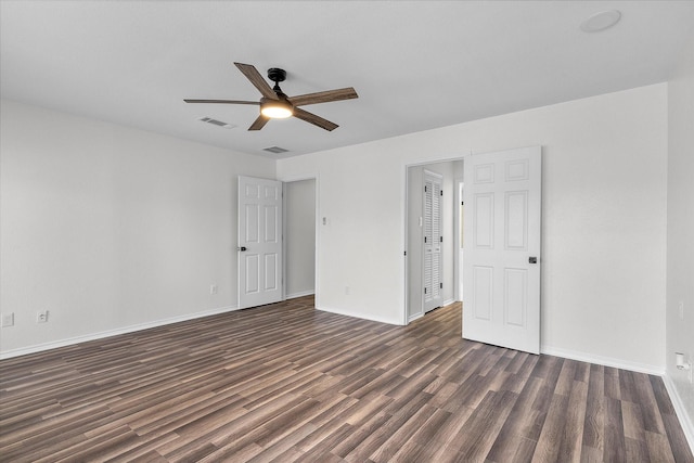 unfurnished room with a ceiling fan, baseboards, visible vents, and dark wood-type flooring