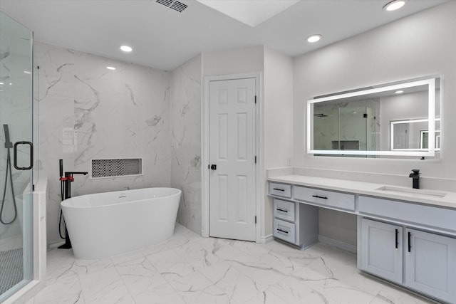 bathroom with visible vents, a soaking tub, marble finish floor, vanity, and recessed lighting