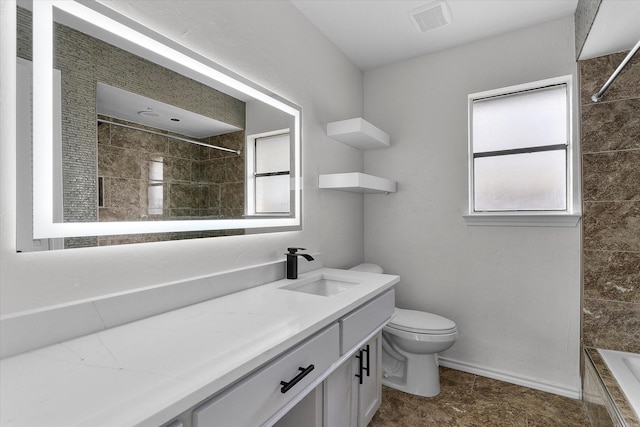 full bathroom featuring tiled shower / bath combo, vanity, and toilet