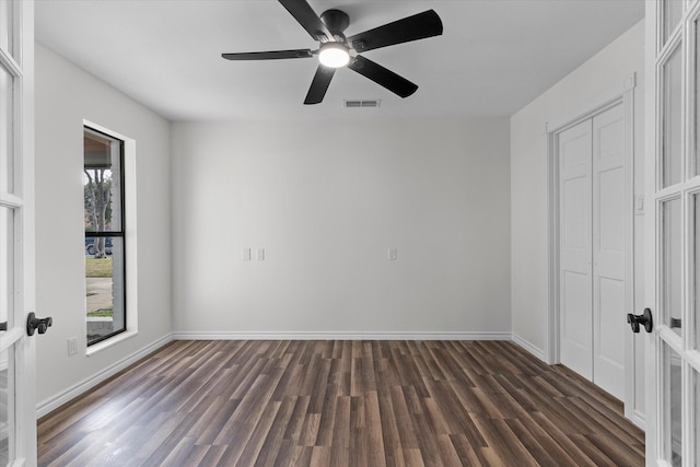 unfurnished bedroom with a closet, visible vents, dark wood-type flooring, ceiling fan, and baseboards