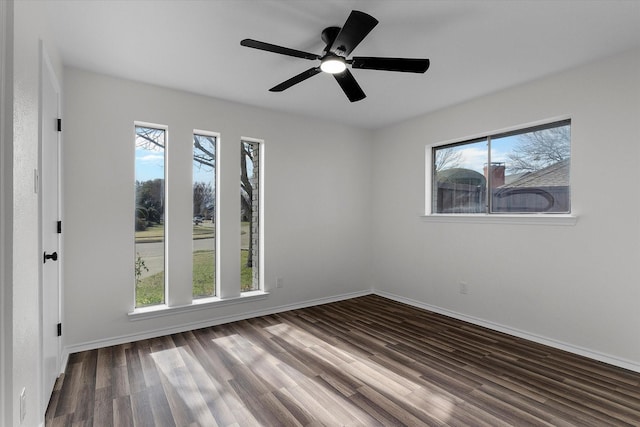 unfurnished room featuring plenty of natural light, wood finished floors, and baseboards